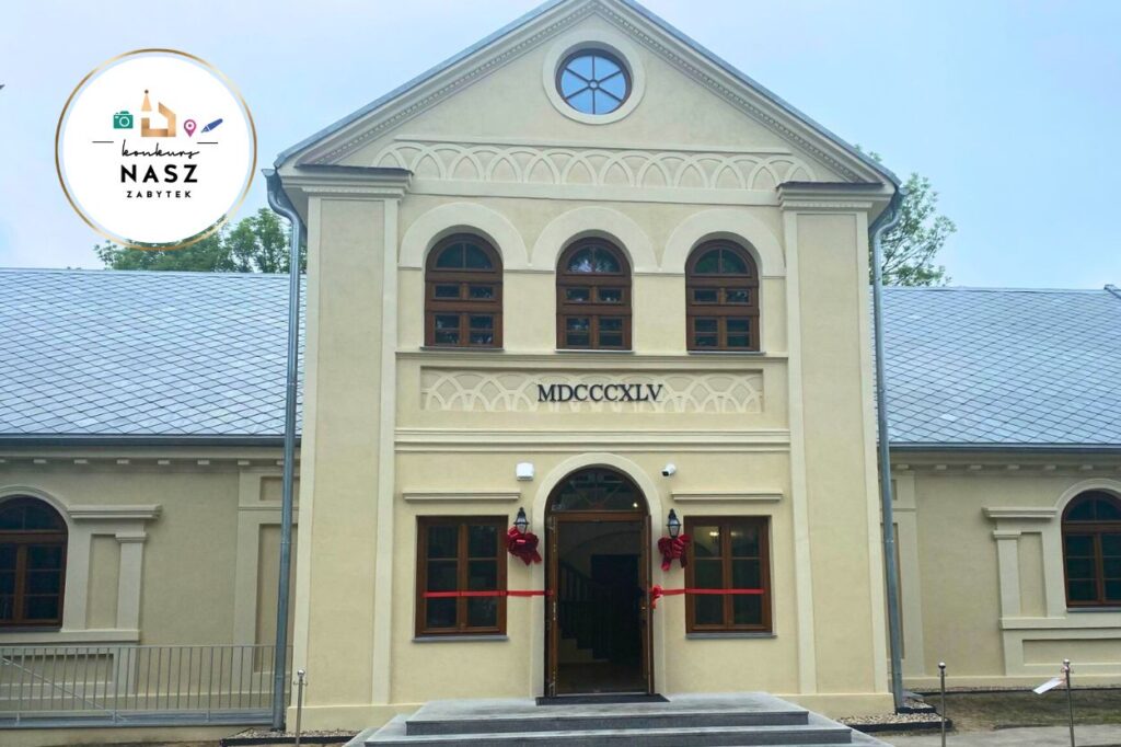 Zrewaloryzowany dworek w Uniejowie z zewnątrz. W lewym górnym rogu logo konkursu nasz zabytek.